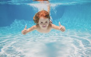 bigstock Child Swimming Underwater With 450734175