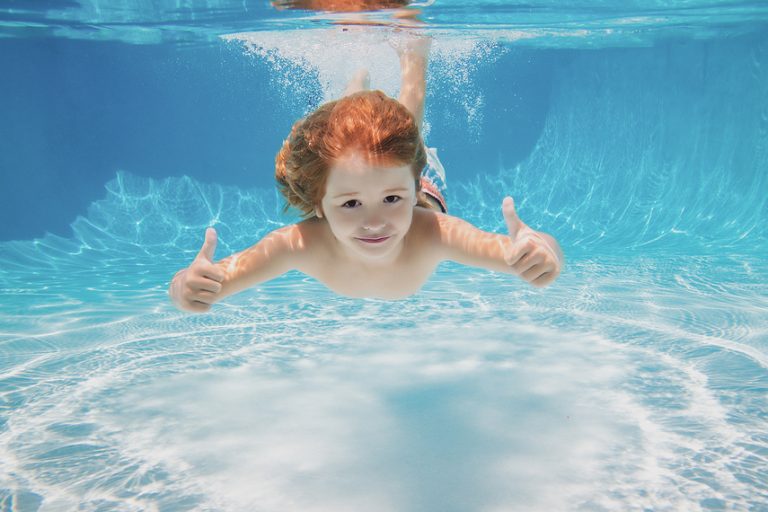 bigstock Child Swimming Underwater With 450734175